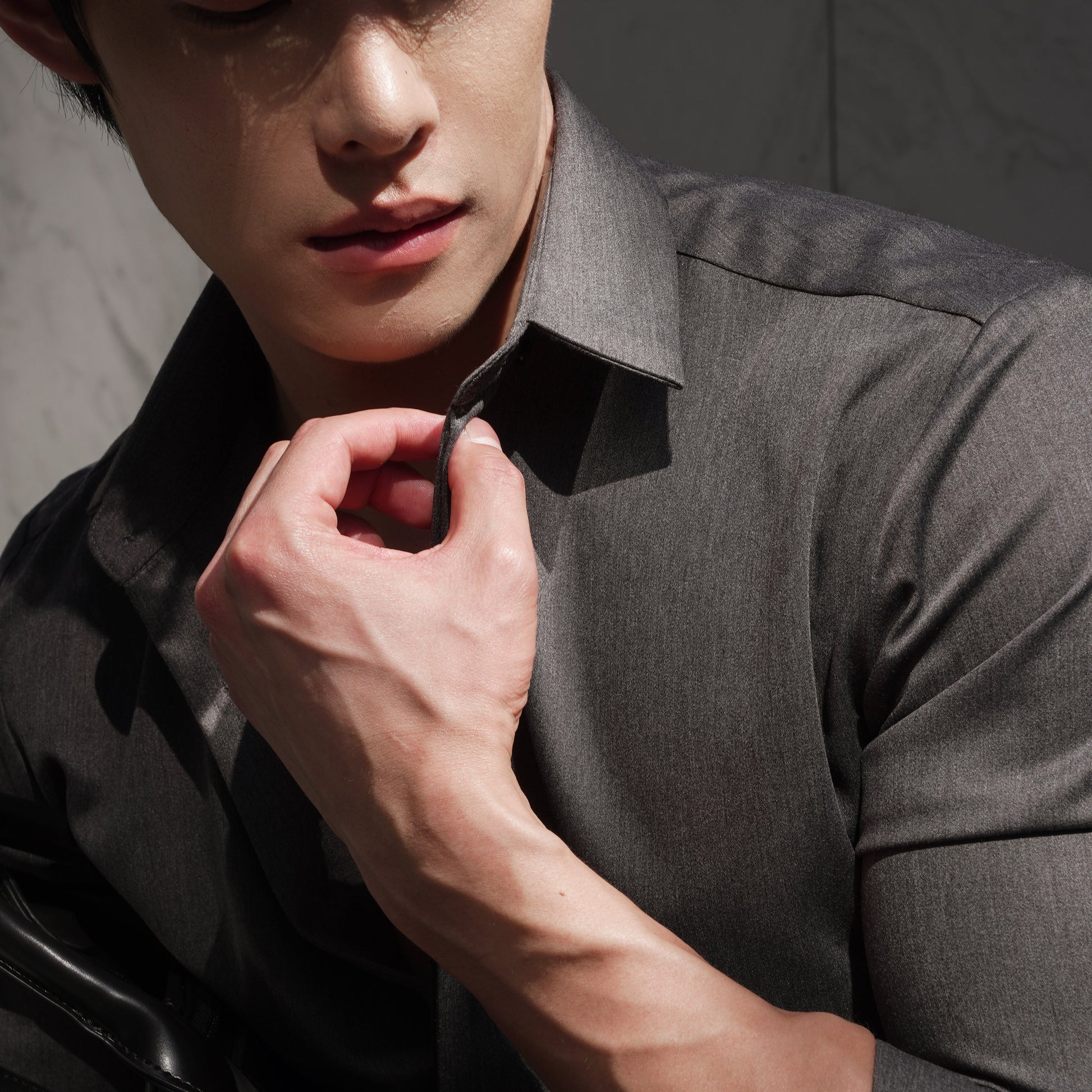 Man adjusting his collar with a neutral background